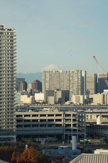 City towers with a snow-capped mountain faint on the horizon