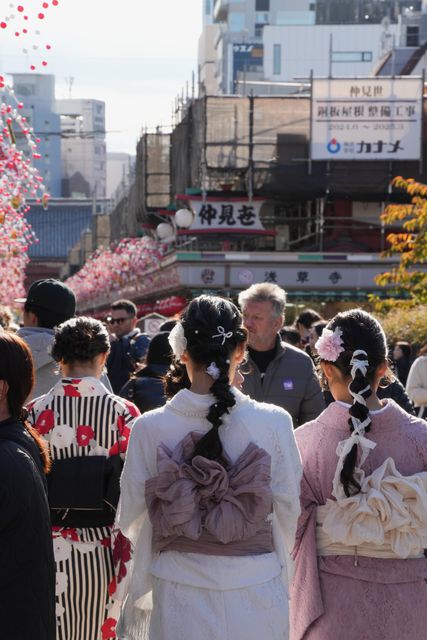 People in kimono seen from behind in a busy street