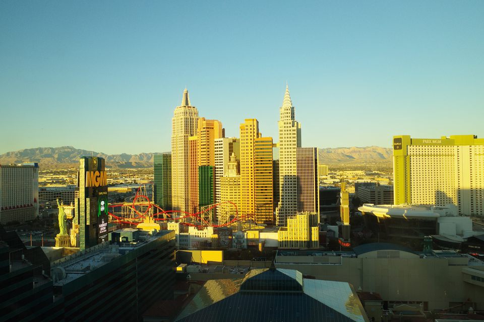Hotel towers of the Las Vegas Strip in warm early light, mountains behind